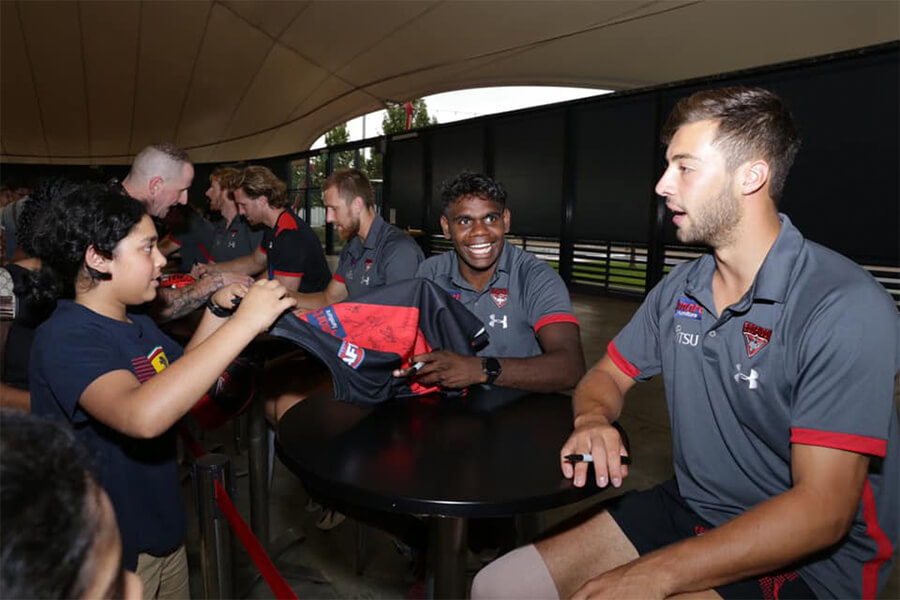 Essendon Football Club players signing their autographs for kids 