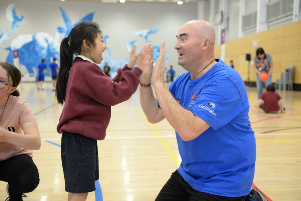 Special Olympics coach giving encouragement to a young participant
